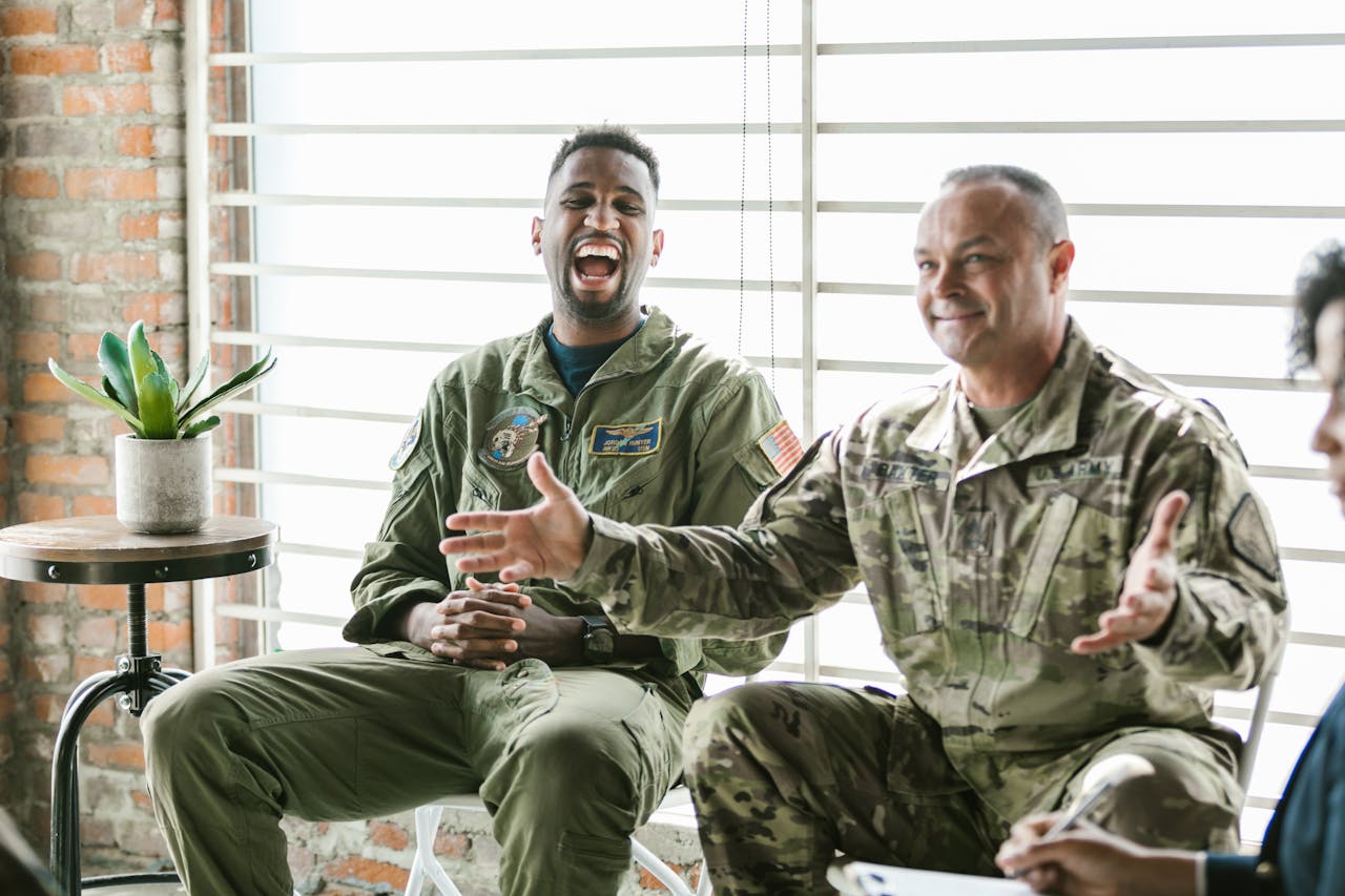 Two soldiers in therapy session, laughing and engaging, highlighting mental health support.